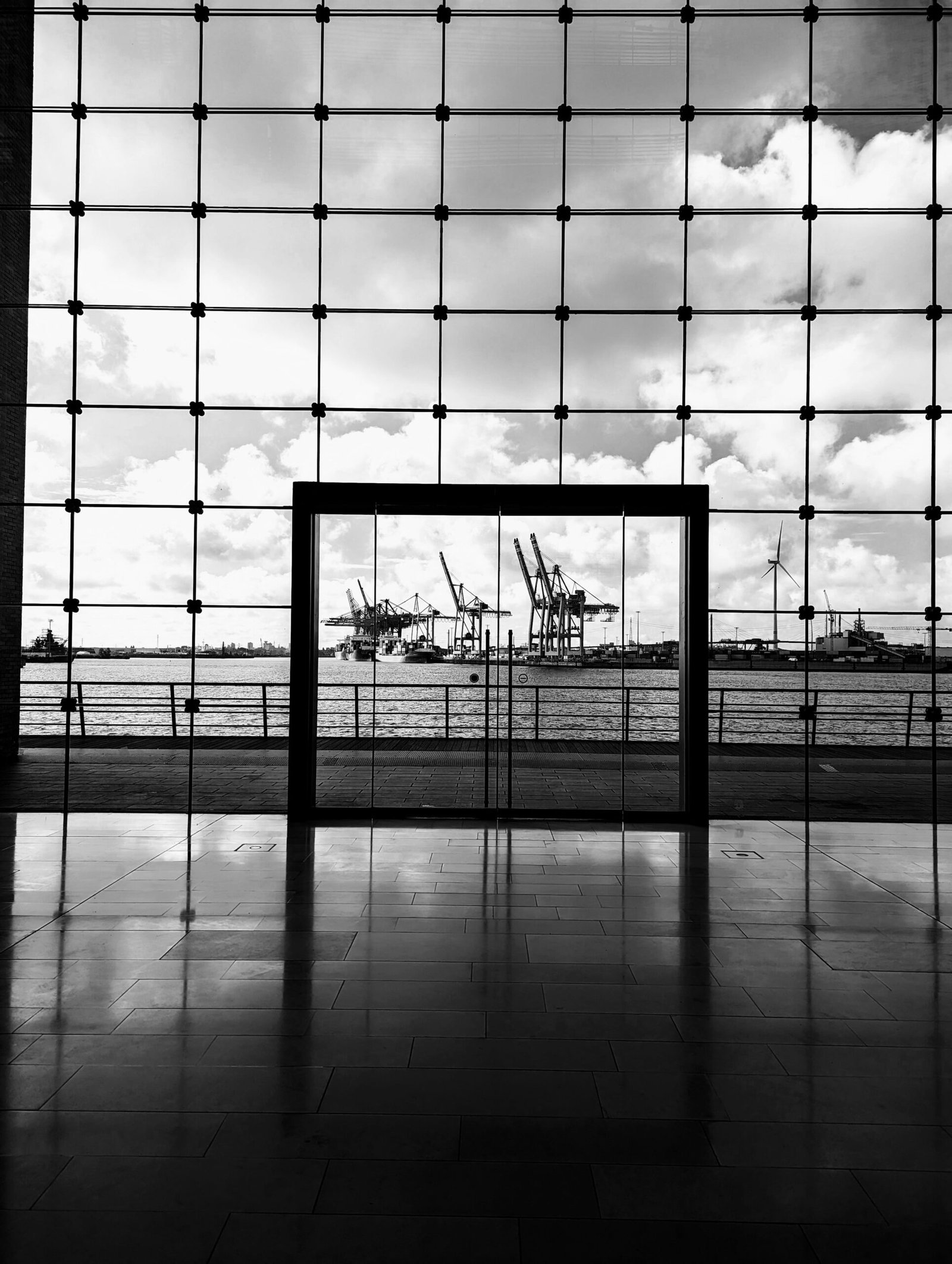 a black and white photo of a window with a view of a harbor